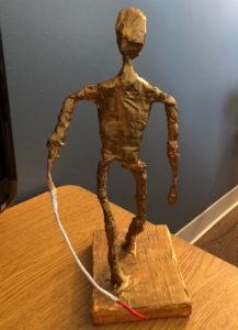 a thin paper mache sculpture painted in gold, using a cane.