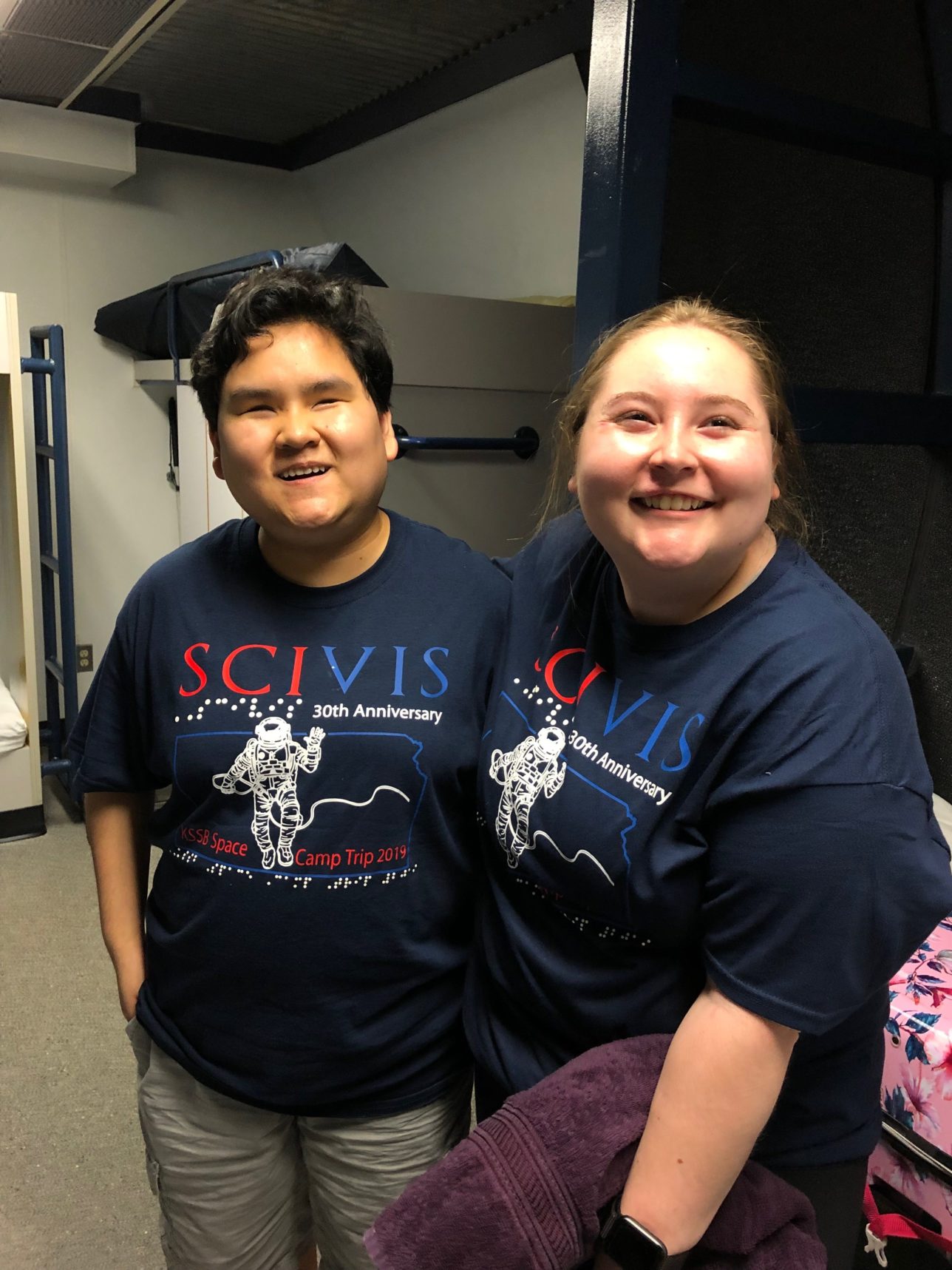 Two female students smiling and wearing space camp t-shirts.