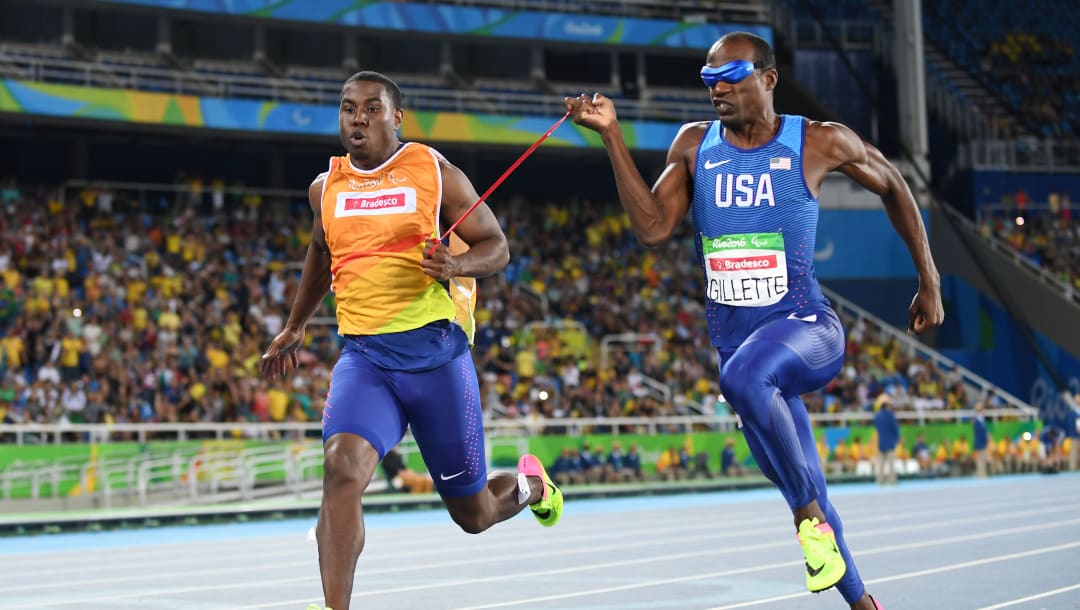 Lex Gillette running with his guide in the olympics