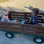 3 students riding in a wagon