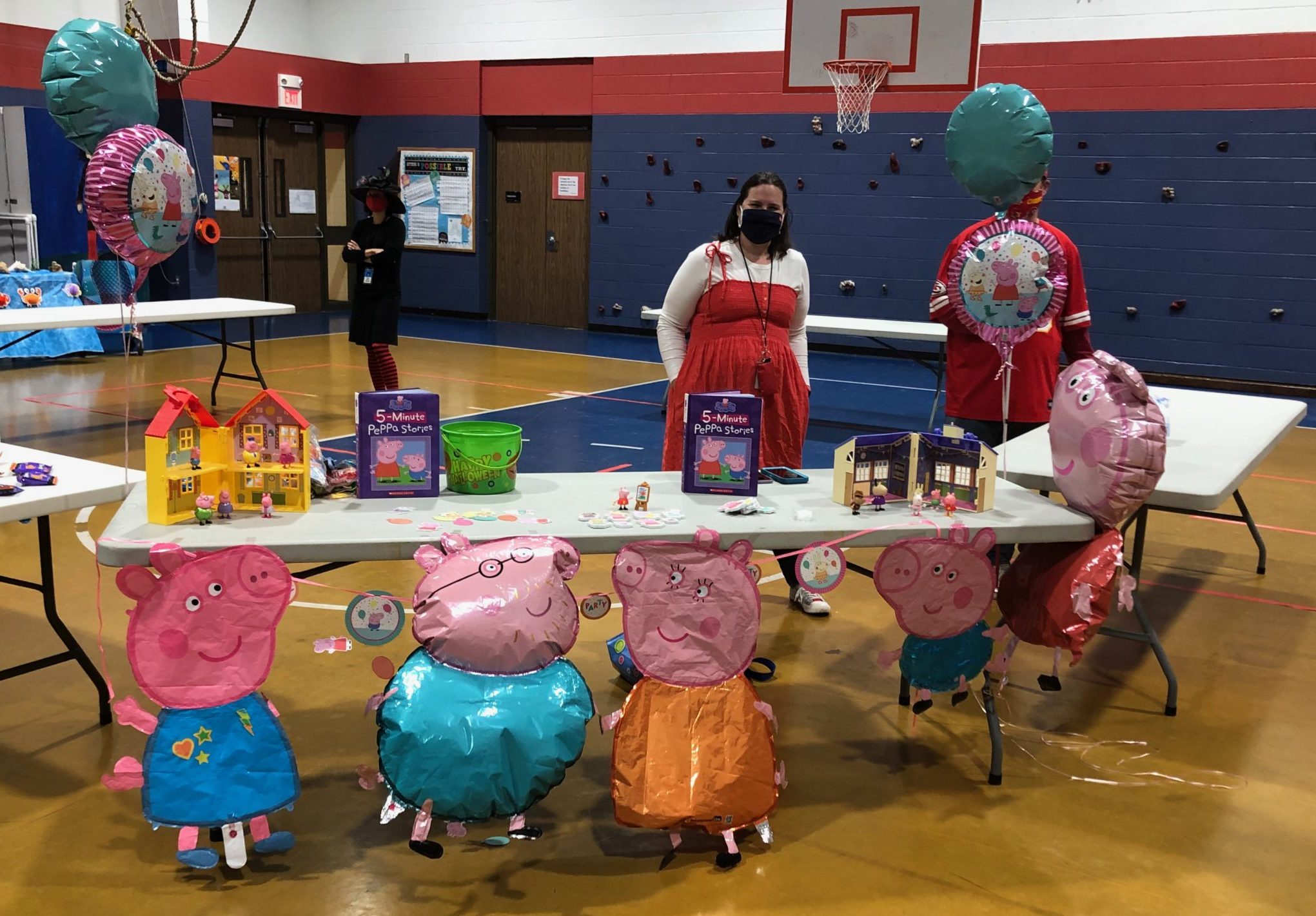 Ms. Hillary's and her table decorated with Peppa Pig balloons and items