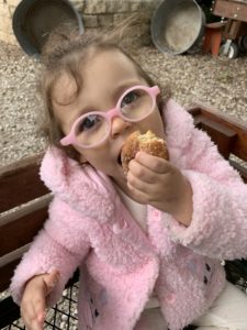 girl wearing glasses enjoys a donut