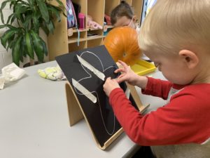 boy adding tape to a person outline on a black piece of paper