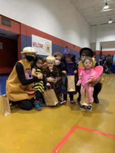 preschool students and teachers dressed up in halloween costumes enjoying trunk-or-treat