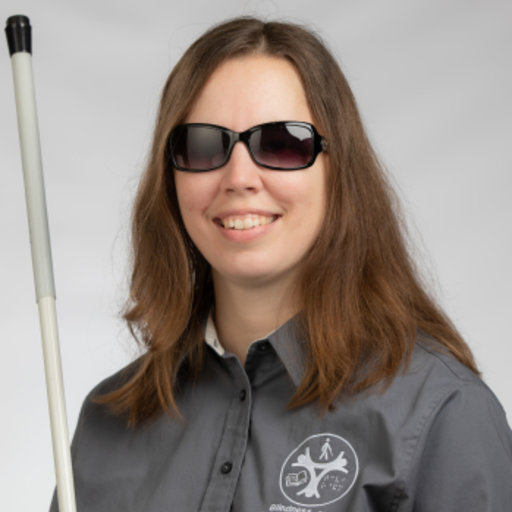 Sarahelizabeth Baguhn smiling wearing sunglasses and holding cane