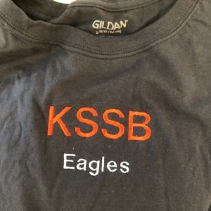 Grey T-shirt With KSSB In Orange And Eagles Below In White, The T-shirt Was Created By Students At The KSSB Makerspace