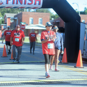 Three people cross the finish line at the KCBAS 5K.