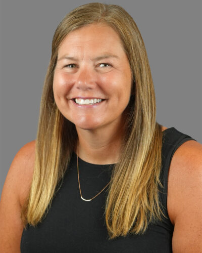 Headshot of Leah Enright, with long blonde hair, smiling for the camera.