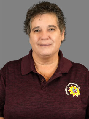 Aundrayah Shermer has short brown hair, wears a maroon polo shirt and smiles for the camera.